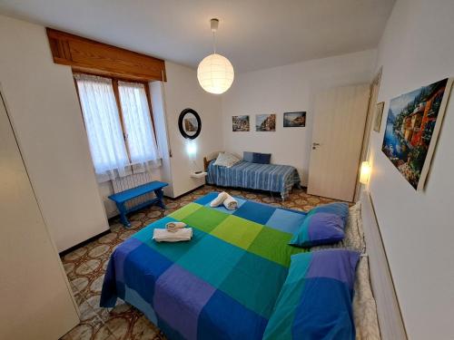 a bedroom with a blue and green bed and a couch at Green House Olivedo in Varenna