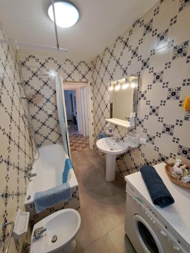 a bathroom with a sink and a toilet and a mirror at Green House Olivedo in Varenna