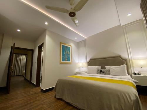 - une chambre avec un grand lit et un ventilateur de plafond dans l'établissement Rosewood Lahore, à Lahore