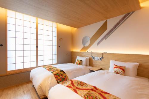 two beds in a room with two windows at Higashiyama Hills - Vacation STAY 41308v in Kyoto