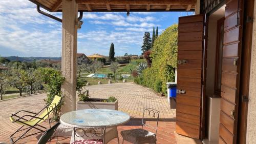 eine Terrasse mit einem Tisch und Blick auf einen Innenhof in der Unterkunft Agriturismo Nonna Bettina in Moniga