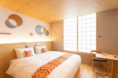 een slaapkamer met een groot bed en een bureau bij Higashiyama Hills - Vacation STAY 41300v in Kyoto