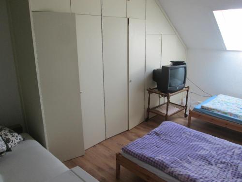 a small room with a bed and a tv at Pension Werner Nagel in Wewelsfleth