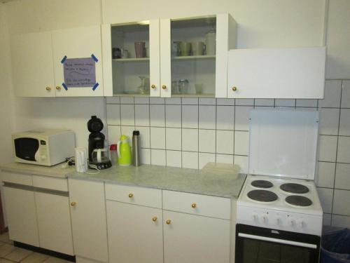 a kitchen with white cabinets and a stove top oven at Pension Werner Nagel in Wewelsfleth