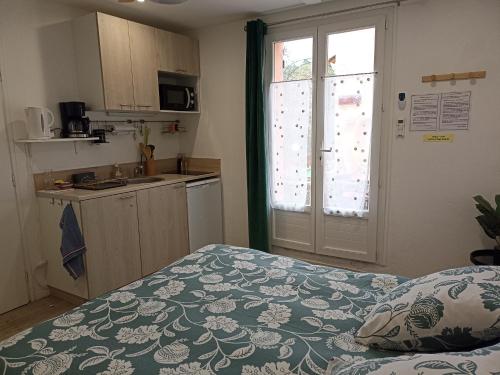 Zimmer mit einem Bett und einer Küche mit einer Tür in der Unterkunft " LE CHABASSOLE " CHAMBRES D'HÔTES - Massages - Jacuzzi - Sauna - GORGES DU VERDON in Aiguines