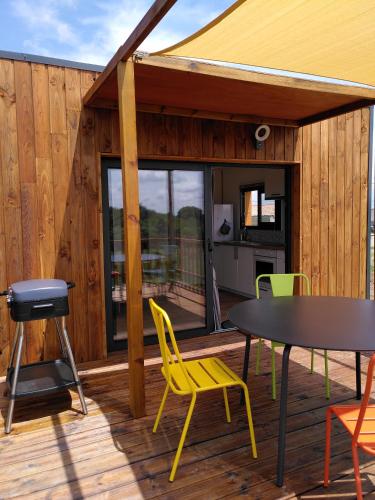 une terrasse avec une table, des chaises et un grill dans l'établissement Maison sur pilotis, à Saint-Palais