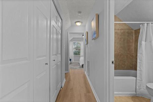 a hallway of a bathroom with a tub and a toilet at Beautifully updated home! Near downtown & NC State in Raleigh