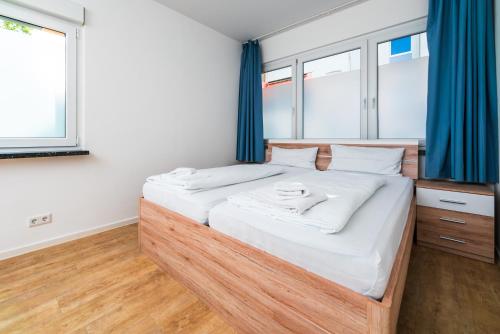sypialnia z dużym łóżkiem z niebieskimi zasłonami w obiekcie City Rooms Dortmund w Dortmundzie