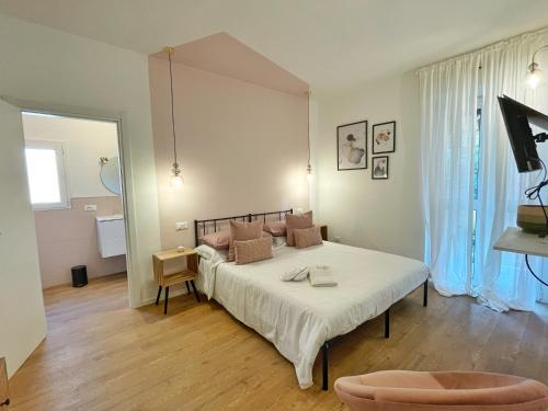 1 dormitorio con 1 cama con sábanas blancas y almohadas marrones en BeHappyS Deluxe Apartment-Charming Balcony en Bolonia
