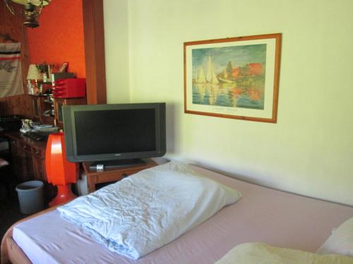 a bedroom with a bed and a tv on a table at Pension Werner Nagel in Wewelsfleth