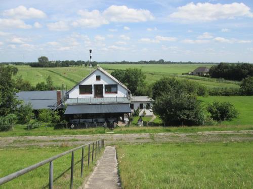 a house in the middle of a field with a fence at Pension Werner Nagel in Wewelsfleth