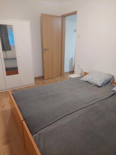 ein Schlafzimmer mit einem großen Bett und einem Spiegel in der Unterkunft Apartman Ždralović in Lipik