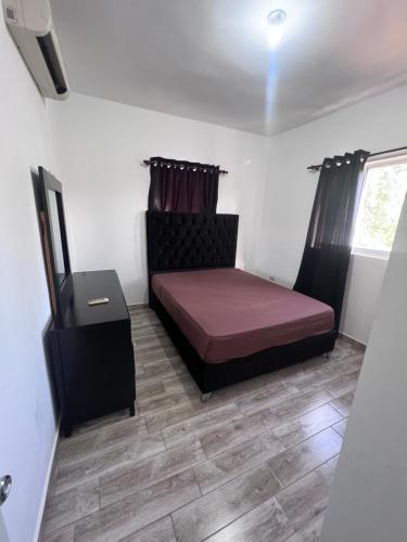 um pequeno quarto com uma cama e uma janela em Vázquez apartamentos em La Piña