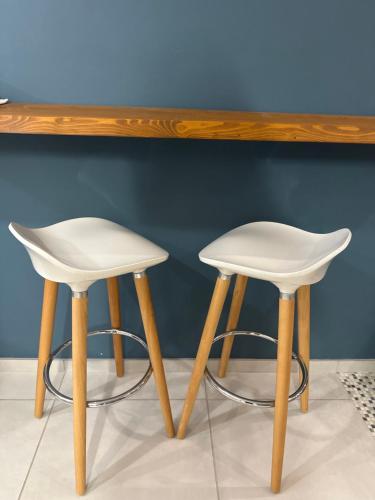 two white stools sitting under a wooden table at Daria in Pedmore
