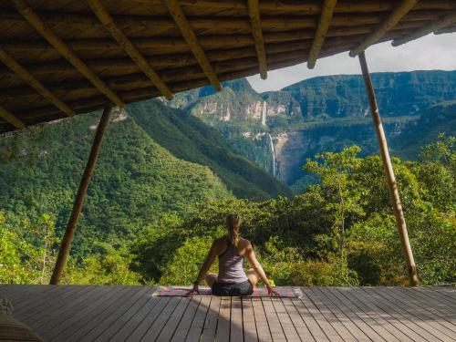 a woman sitting on a deck looking at the mountains at GoctaLab in Cocachimba