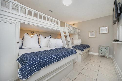 a bedroom with two bunk beds with blue and white pillows at Caribbean Breeze in Seacrest