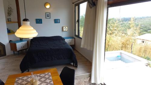 ein Schlafzimmer mit einem Bett und einem großen Fenster in der Unterkunft Cabaña La Emilia - Villa Giardino in Villa Giardino