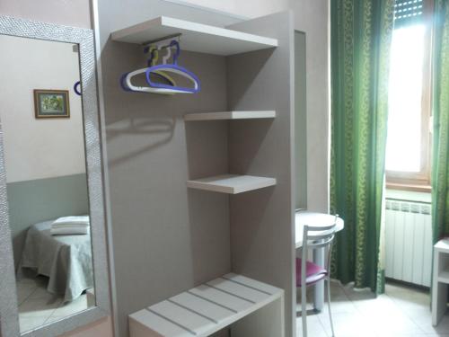 a closet with shelves and a mirror in a room at Hotel Le Querce in Milan