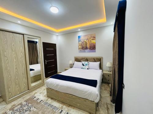 a bedroom with a large bed and a mirror at Capital Of Pyramids Hotel in Cairo