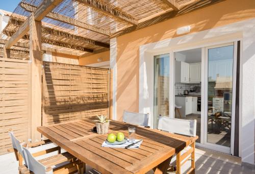 a dining room with a wooden table and chairs at Reiki Apartments in Ereikoússa