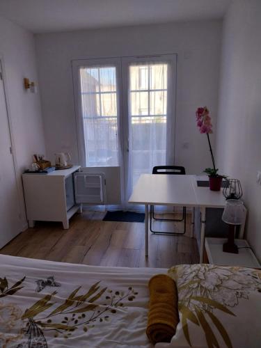een kamer met een bed, een bureau en ramen bij Doma Anna in Blois