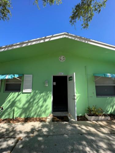 een groen gebouw met een deur ervoor bij Newly remodeled, Cozy Cottage in North Palm Beach in North Palm Beach