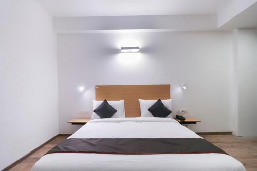 a bedroom with a large bed with black and white pillows at Townhouse Noida Sector 71 Near ISKCON Temple Noida in Indirapuram