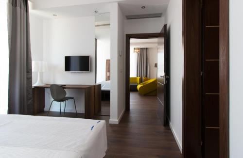 a hotel room with a bed and a desk with a chair at Perla Luxury in Ulcinj