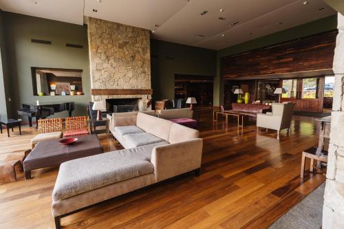 a living room with a couch and a fireplace at Loi Suites Chapelco Hotel in San Martín de los Andes