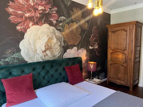 een slaapkamer met een bed met een muurschildering van bloemen aan de muur bij Geschmackvolles Appartement mitten in Düsseldorf in Düsseldorf