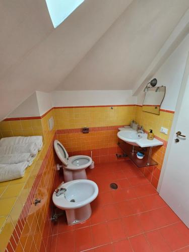 uma casa de banho com 2 WC e um lavatório em Attico Granelli di Sabbia em Lido di Ostia