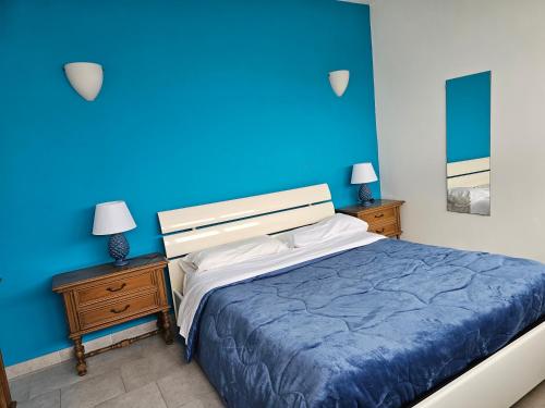 a blue bedroom with a bed and two night stands at Attico Granelli di Sabbia in Lido di Ostia