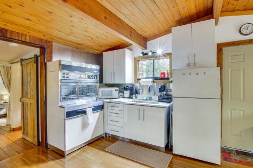 a kitchen with white appliances and a wooden ceiling at Arlington Creekside Cabin with Hot Tub and Fire Pit! in Arlington