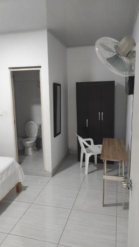 ein weißes Zimmer mit einem Tisch und einem Stuhl in der Unterkunft Hospedaje Norcasia in Norcasia