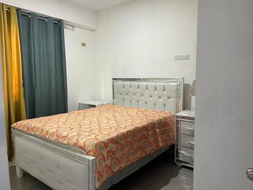 a bedroom with a bed with an orange comforter at Apartamento la familia 2 in Santa Bárbara de Samaná