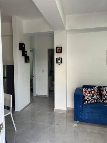 a living room with a blue couch and a chair at Apartamento la familia 2 in Santa Bárbara de Samaná