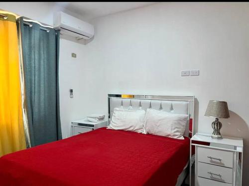 a bedroom with a red bed with a red blanket at Apartamento la familia 2 in Santa Bárbara de Samaná