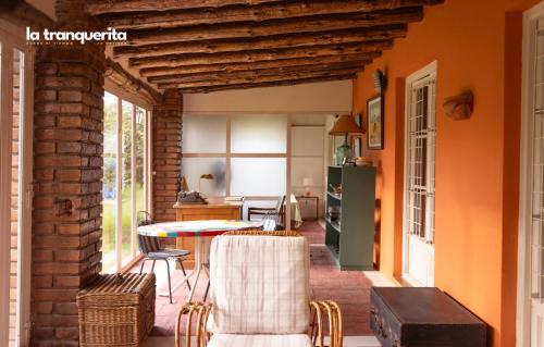 a kitchen and dining room with an orange wall at Finca La Tranquerita in San Rafael