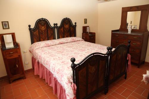 a bedroom with a large wooden bed and a dresser at Al Vecchio Leccio in Pistoia