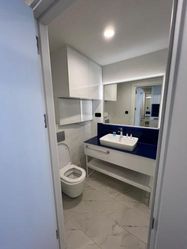 a bathroom with a white toilet and a sink at Orbi city Sea view 5star in Batumi