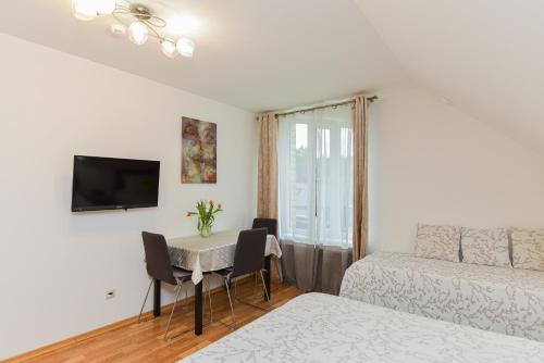 a small room with a table and a bed and a bedroom at Vila Laurus in Palanga