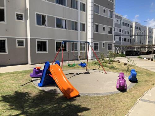 a playground with an orange slide in the grass at RESIDENCIAL ALAMEDA JARDINS in Aracaju