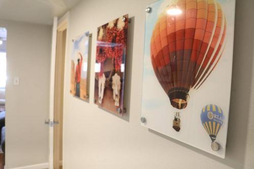 a wall with pictures of a hot air balloon at Cowboy Den-Hot Tub-Game Room-Pet Friendly-No Pet Fees! in Albuquerque