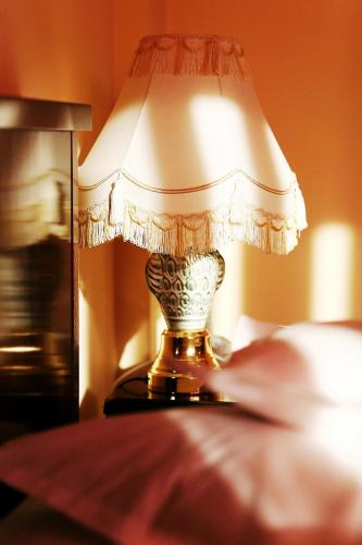 a lamp sitting on a table next to a bed at Hotel Premier in Cluj-Napoca