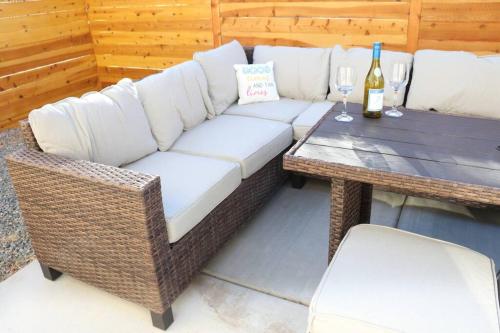 a white couch and a table with a bottle of wine at Cowboy Den-Hot Tub-Game Room-Pet Friendly-No Pet Fees! in Albuquerque