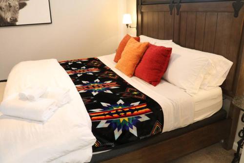a bed with colorful pillows on it in a room at Cowboy Den-Hot Tub-Game Room-Pet Friendly-No Pet Fees! in Albuquerque