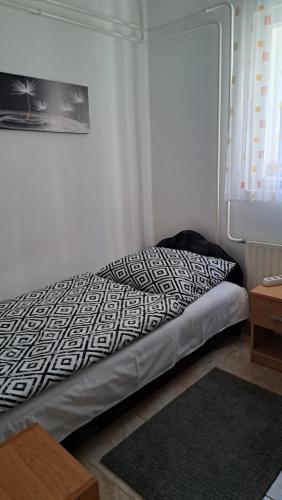 1 dormitorio con 1 cama con edredón blanco y negro en Villa Julia, en Budapest