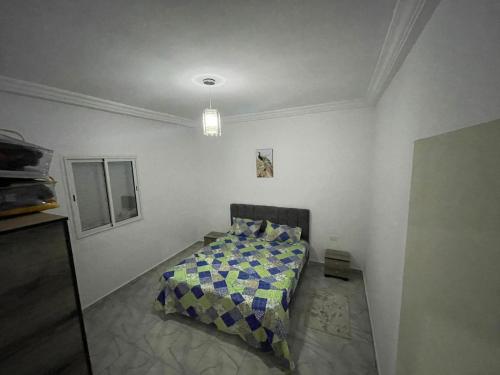 a bedroom with a bed in a white room at DIaR MAHER in Al Maqārisah