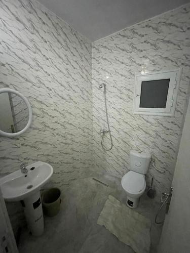 a bathroom with a toilet and a sink at DIaR MAHER in Al Maqārisah