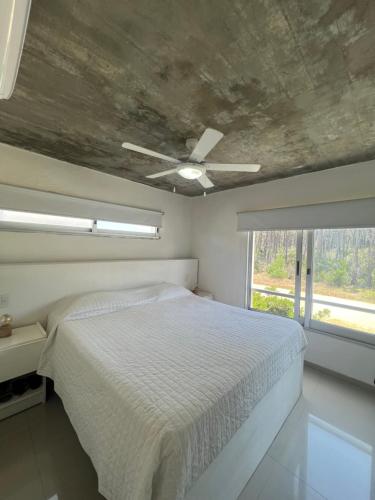 a bedroom with a bed and a ceiling fan at Arenas Garzón A 8 in José Ignacio